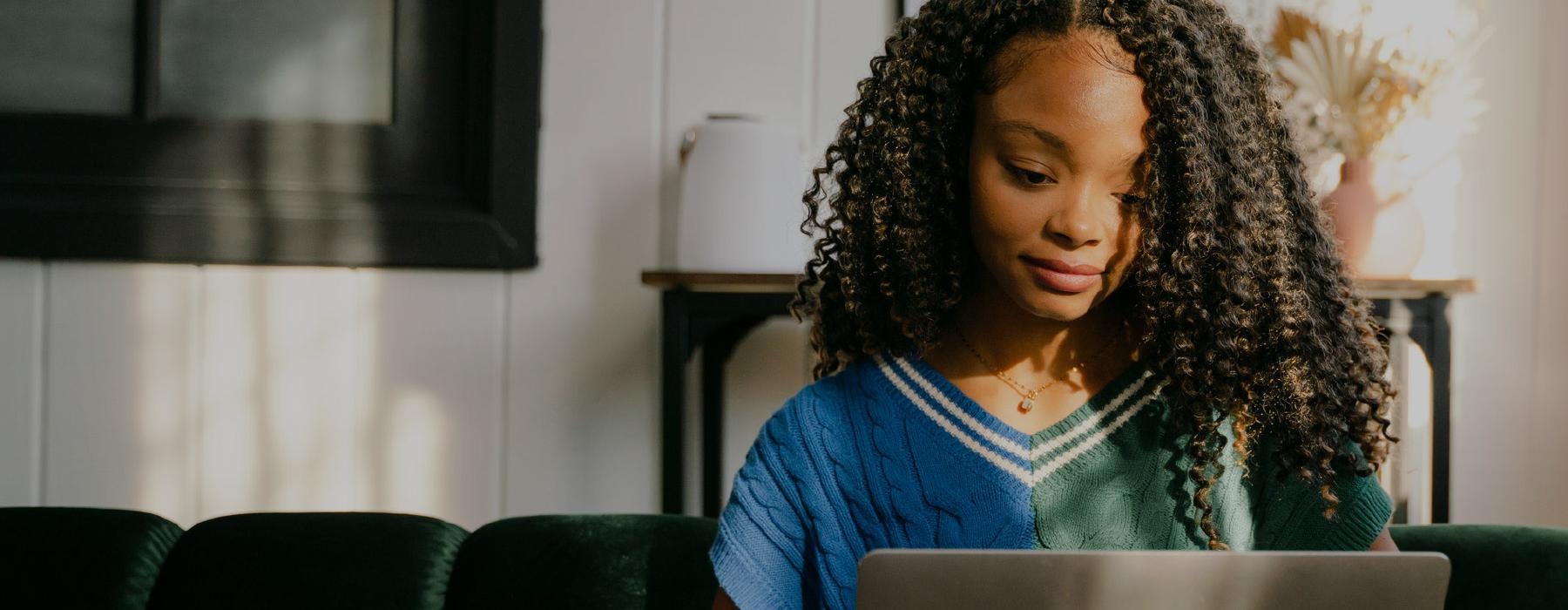 a woman sitting in a chair at her laptop